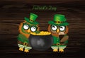 Two happy owls with a pot of gold coins in a national costume an