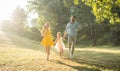 Two happy parents running together with their cute daughter