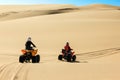 Quad driving people - two happy bikers in sand desert dunes, Africa, Namibia, Namib, Walvis Bay, Swakopmund. Royalty Free Stock Photo