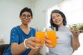 Two happy retired Asian female friends are enjoying their healthy salad and orange juice together Royalty Free Stock Photo