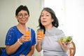 Two happy retired middle-aged Asian women sitting in a dining room Royalty Free Stock Photo