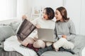 Two happy roommates buying together on line with credit card and a laptop at home