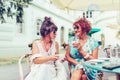 Two happy senior women talking and drinking coffee in a outdoor cafe Royalty Free Stock Photo