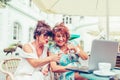 Two happy senior women using laptop and pointing at screen surprised Royalty Free Stock Photo