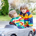 Two happy sibling boys playing with big old toy car Royalty Free Stock Photo