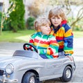 Two happy sibling boys playing with big old toy car Royalty Free Stock Photo