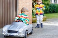 Two happy sibling boys playing with big old toy car Royalty Free Stock Photo