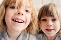 Two happy sibling boys playing together at home with toy cars