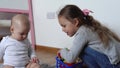 Two Happy Siblings Children Boy Girl In Playing Room. Kids Infand and Preschool Play With Wooden Toy At Home Build