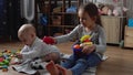 Two Happy Siblings Children Boy Girl In Playing Room. Kids Infand and Preschool Play With Wooden Toy At Home Build