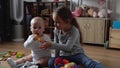 Two Happy Siblings Children Boy Girl In Playing Room. Kids Infand and Preschool Play With Wooden Toy At Home Build