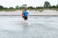 Two happy siblings children in neoprene swimingsuit  playin and running in sea Royalty Free Stock Photo