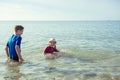 Two happy siblings children in neoprene swimingsuit  playing in sea Royalty Free Stock Photo