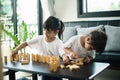 Two happy siblings playing a game with wooden blocks at home joyfully Royalty Free Stock Photo