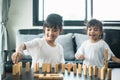 Two happy siblings playing a game with wooden blocks at home joyfully Royalty Free Stock Photo