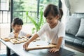 Two happy siblings playing a game with wooden blocks at home joyfully Royalty Free Stock Photo