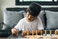 Two happy siblings playing a game with wooden blocks at home joyfully Royalty Free Stock Photo