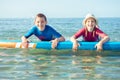 Two happy siblings teen children in neoprene suits having fun with sup board in Baltic sea