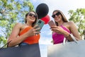Two happy sisters with shopping bags and balloons walking outdoor holding a smartphone. beautiful women having fun on summer shop Royalty Free Stock Photo