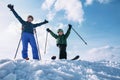 Two happy skiers stay together on the top of snow hill