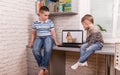 Two happy small friends. Boys using smart digital tablet at home. Royalty Free Stock Photo