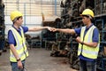 Two happy smiling Asian industrial engineer men with safety vest and helmet fist bumping hand after complete work at manufacturing Royalty Free Stock Photo