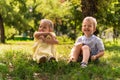 Two happy smiling cheerful toddler preschool twins siblings children brother sister boy girl sitting together on grass Royalty Free Stock Photo