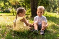 Two happy smiling cheerful toddler preschool twins siblings children brother sister boy girl sitting together on grass Royalty Free Stock Photo