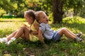 Two happy smiling cheerful toddler preschool twins siblings children brother sister boy girl sitting together on grass Royalty Free Stock Photo