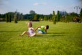 two happy smiling children tumbling on green grass. Cheerful brother and sister laugh together. Happy kids have fun on