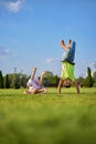 two happy smiling children tumbling on green grass. Cheerful brother and sister laugh together. Happy kids have fun on
