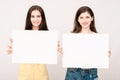 Two happy smiling young women carring big blank signboard Royalty Free Stock Photo