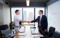 Two happy successful business partner shaking hands in the office. Royalty Free Stock Photo