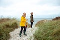 Two happy teenager siblings staing with ambrella on coast of Baltic sea at windy weather Royalty Free Stock Photo