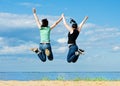 Two happy women jumping on the beach Royalty Free Stock Photo