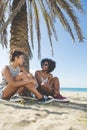 Two happy women sitting on beach laughing Royalty Free Stock Photo