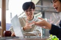 Two happy young Asian college students are discussing and working on a project in a cafe together Royalty Free Stock Photo