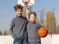 Two happy young boys on basketball field outdoors on a sports ball Royalty Free Stock Photo