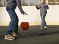 Two happy young boys playing basketball outdoors on a sports field Royalty Free Stock Photo