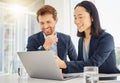 Two happy young diverse colleagues working together on a laptop in an office boardroom. Confident asian businesswoman Royalty Free Stock Photo