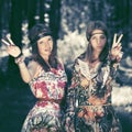 Two happy young fashion girls walking in summer forest