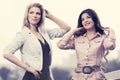 Two happy young fashion women walking on city street Royalty Free Stock Photo