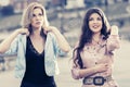 Two happy young fashion women walking on city street Royalty Free Stock Photo