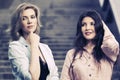 Two happy young fashion women walking on city street Royalty Free Stock Photo