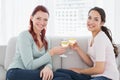 Two happy young female friends toasting wine glasses at home Royalty Free Stock Photo