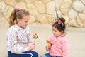 Two happy young girls in a city street. Toddler girl dressing up as a unicorn.