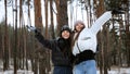 Two happy young girls having fun together and catching snowflakes during snow storm in forest. People playing outdoors, winter Royalty Free Stock Photo