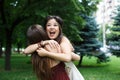 Two happy young girls hug each other in summer park Royalty Free Stock Photo