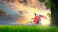 Happy young local boy riding old bicycle at paddy field holding a Malaysian flag. Independence Royalty Free Stock Photo