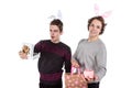 Two happy young men in a rabbit-like ears holding up gift boxes. Isolated on white background Royalty Free Stock Photo